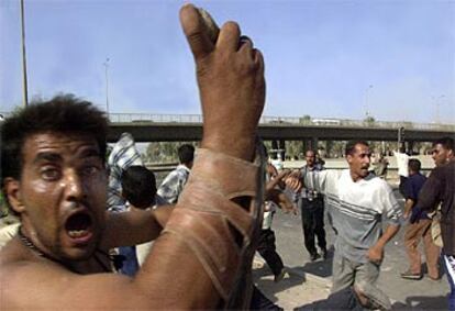 Un ex militar iraquí lanza una piedra contra la base aérea de Muthana, donde hacía cola para cobrar su salario.