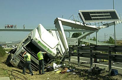 Agentes de la Guardia Civil examinan el camión accidentado en la autovía de A Coruña.