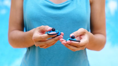 Una mujer con tapones para los oídos en las manos