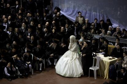 An ultra-Orthodox Jewish bride enters to the men's section of the wedding, to fulfill the Mitzvah tantz, in which family members and honored rabbis are invited to dance in front of the bride, often holding a gartel, and then dancing with the groom, during her wedding to the grandson of the Rabbi of the Tzanz Hasidic dynasty community, in Netanya, Israel,in Netanya, Israel, Wednesday, March 16, 2016. (AP Photo/Oded Balilty) 