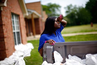 Kimberly Nailor descansa mientras pone sacos de arena para proteger su casa ante una previsible crecida del río Misisipi a su paso por Memphis.