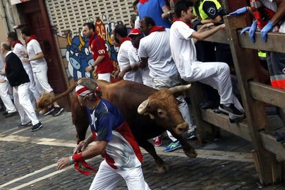 Toro de la ganadería de Cebada Gago, que han protagonizado un encierro muy peligroso, con al menos cinco heridos por asta, pasa por la curva de Mercaderes durante el segundo encierro de los Sanfermines de 2016.