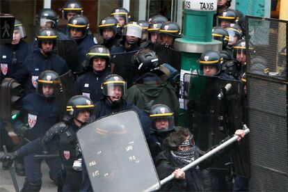 Un grupo de policías antidisturbios carga contra un manifestante armado con una barra, ayer en París.