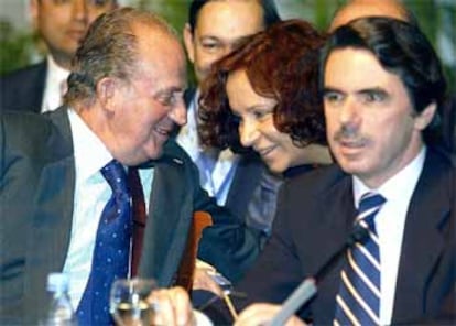 El Rey conversa con la ministra española de Exteriores, Ana Palacio, en presencia de Aznar durante la primera sesión de la Cumbre.