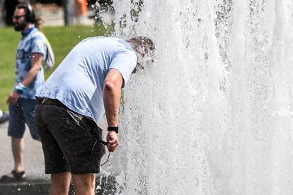 Un hombre se refresca en una fuente pública en Berlín (Alemania), este lunes.