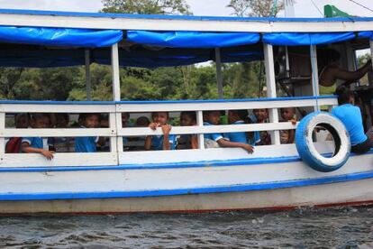 Crianças a caminho da escola, em barco.