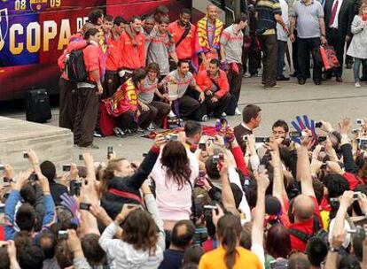 Aficionados azulgrana reciben a los jugadores del Barcelona a su llegada al Camp Nou.