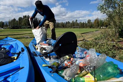 Un hombre recolecta envases de plástico de los canales de Xochimilco, en Ciudad de México, el 25 de enero de 2022.