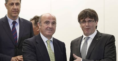 El presidente de la Generalitat, Carles Puigdemont saluda al ministro de Economía, Industria y Competitividad del Gobierno, Luis de Guindos, en presencia del presidente del PPC, Xavier Garcia Albiol.