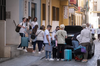 Varios jóvenes cargados con maletas salen de un piso turístico en Sevilla