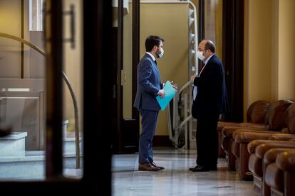 El 'president' en funciones del Govern, Pere Aragonés (i), habla ayer con líder del PSC, Miquel Iceta (d), en la puerta del hemiciclo del Parlament