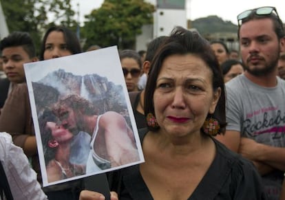 Una mujer sostiene una fotograf&iacute;a de la exmiss y su marido, el jueves