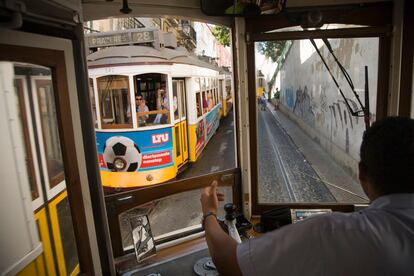 Dos tranvías de la mítica línea 28 se cruzan durante su recorrido por las calles de Lisboa