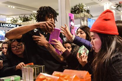 Un dependiente reparte colonias en la sección de perfumería de la tienda Macy's de Nueva York (EE UU).