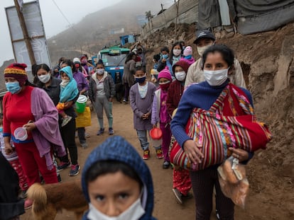 Moradores do bairro de Nueva Esperanza, em Lima (Peru), esperam por um prato de comida em frente a um refeitório comunitário, em 17 de junho de 2020.