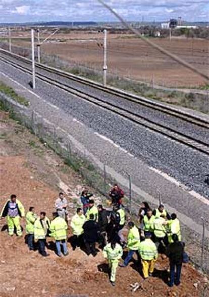 Guardias civiles y operarios de Renfe, junto a las vías del AVE Madrid-Sevilla donde fue hallada la bomba.