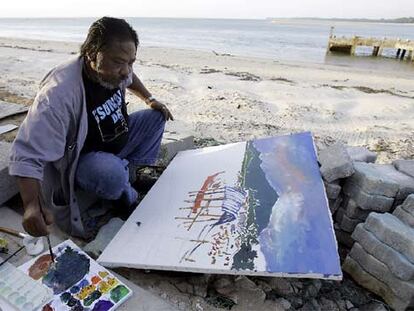 El artista Charoon Siyaphan pinta en la playa de Ban Nam, en la provincia de Phang Nga, en el sur de Tailandia.