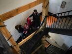 MADRID.03-11-2020. Jos�, nacido en Angola, ayuda a una vecina y su hija a bajar las escaleras en el Palacio de la Infanta Carlota de la calle de la Luna, 32. FOTO: LUIS DE VEGA