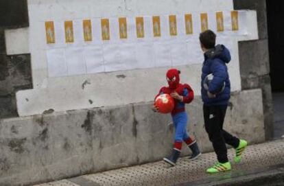 Dos niños pasan junto a los poemas pegados en las calles de Andoain.