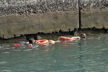 Dos personas con flotadores salvavidas en el puerto de La Restinga (El Hierro), este miércoles.