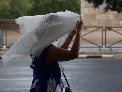 Una mujer se protege de la lluvia durante la tormenta caída el lunes en Valencia.