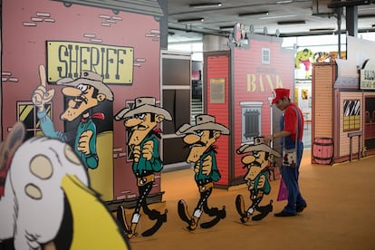 Un visitante disfrazado de Super Mario observa la exposicon de Lucky Luke.