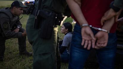 Agentes estatales de Texas detienen migrantes tras haber cruzado la frontera, el 13 de junio en Mission.