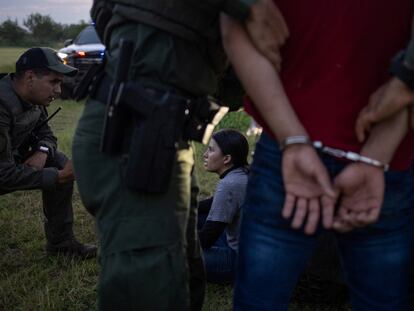 Agentes estatales de Texas detienen migrantes tras haber cruzado la frontera, el 13 de junio en Mission.