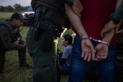 Agentes estatales de Texas detienen migrantes tras haber cruzado la frontera, el 13 de junio en Mission.