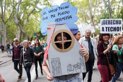 Una manifestante disfrazada de una vivienda con el cartel "El único techo que me puedo permitir", este domingo en Madrid. 