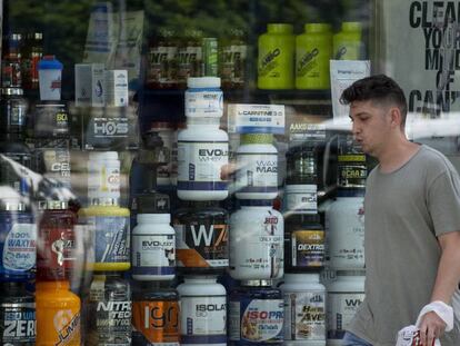 Un joven pasa frente a una tienda de suplementos alimenticios en Sevilla.