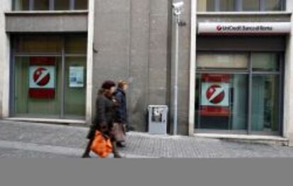 Dos transeuntes pasan delante de una sucursal de Unicredit en Viterbo, Italia. El primer grupo bancario del país está registrando las mayores caídas bursátiles de la zona euro tras el rescate a Chipre.