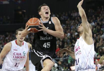 El base lituano del Bizkaia Bilbao Basket, Janis Blums, entra a canasta ante la oposición del escolta del Caja Laboral  David Logan.