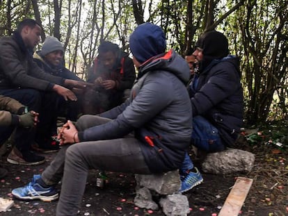 Un grupo de migrantes se calienta alrededor de un fuego, este viernes en Calais.