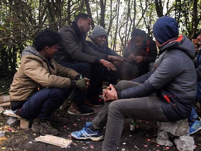 Un grupo de migrantes se calienta alrededor de un fuego, este viernes en Calais.