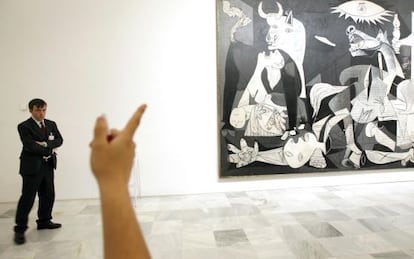 Un visitante señala el 'Guernica'.