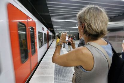 Una dona fotografia el tren a la nova estaci&oacute; del Nord de FGC.