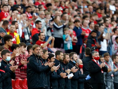 Juergen Klopp y sus asistentes aplauden en la banda durante el homenaje a Michael Robinson en Anfield.