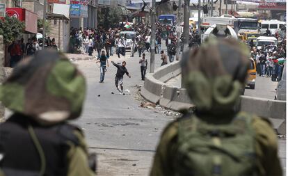 Soldados israelíes observan a los manifestantes palestinos en el puesto de control de Qalandia, en Ramala, que conecta Jerusalén con Cisjordania.