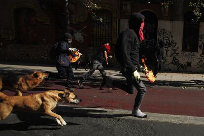 Manifestantes correm para lançar coquetéis molotov.