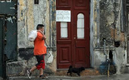 A man walking past a home up for sale in Havana, Cuba.