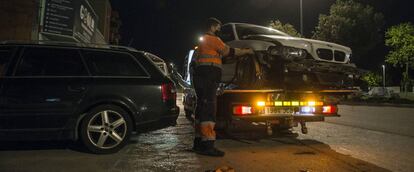 Un operario de grúa recoge un vehículo accidentado en Girona.