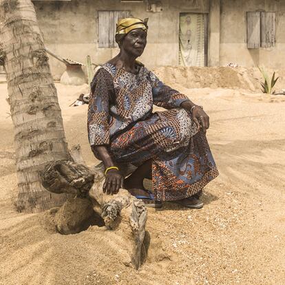 Alice Kwashi, de 68 años, posa en el exterior de su casa, en la aldea ghanesa de Blekusu. El océano ha destruido parte de su casa, la ha llenado de arena y ha contaminado su pozo de agua dulce con agua salada. La mujer ha levantado una pequeña barrera de tierra a la entrada de su vivienda para prevenir las inundaciones. "Cuando me acuesto, no sé si el mar vendrá y me llevará", relata.