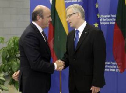 El ministro de Economía español, Luis de Guindos (i), estrecha la mano de su homólogo lituano, Rimantas Sadzius, ayer durante una reunión informal de dos días en Vilna (Lituania).