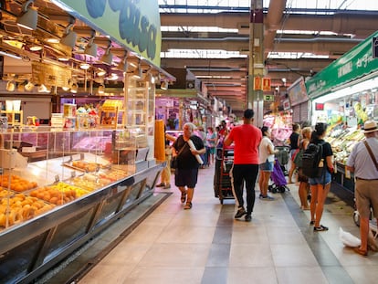 Varias personas hacen la compra en un mercado.