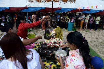 Durante el Songkran, la estatua de Buda se coloca en las calles y da la bienvenida en centros comerciales, apartamentos u oficinas. La figura se moja con agua perfumada para limpiarla en un acto que sirve para purificar el alma e iniciar el año espiritualmente limpio. En la imagen, varios tailandeses bañan un Buda en la provincia tailandesa de Narathiwat.