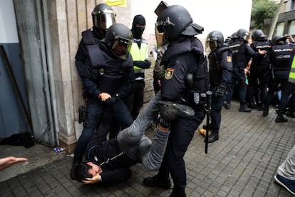 Agentes de la Policía Nacional desalojan la entrada al Instituto Jaume Balmes de Barcelona el 1-O. 