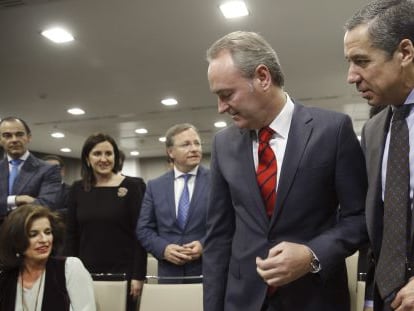 Alberto Fabra y su presentador, el expresidente Eduardo Zaplana, observados por tres consejeros y la alcaldesa de Madrid.