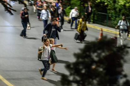 Dos niñas corren al encuentro de sus familiares que salen del aeropuerto de Atatürk, tras la explosión.