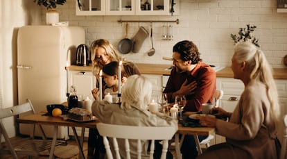 Una familia disfruta de la comida de Navidad con una silla vacía.